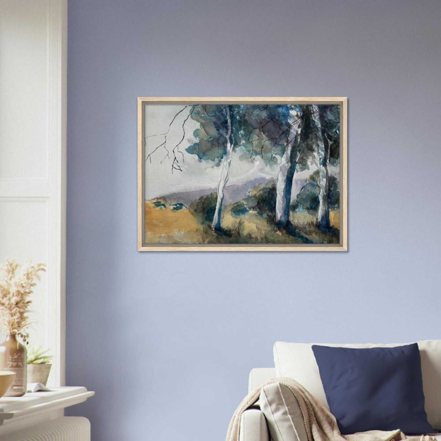 Australian watercolor landscape wall art framed canvas print featuring gum trees and hills, hanging on a wall above a sofa.